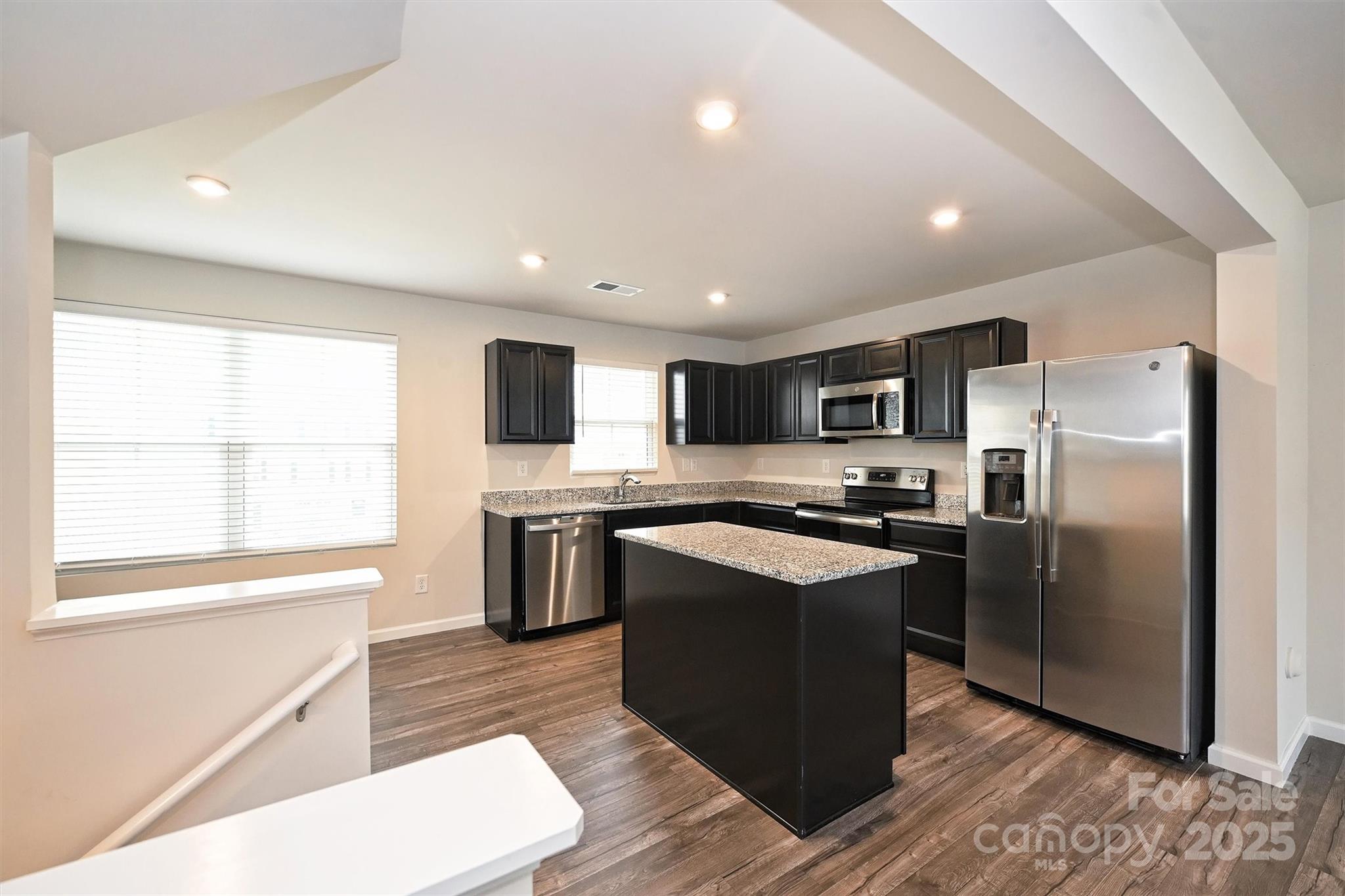 825 Renee Avenue Fort Mill, SC 29715 - Photo 7 of 30 a kitchen with stainless steel appliances granite countertop a refrigerator a sink dishwasher a stove top oven a refrigerator and white cabinets with wooden floor