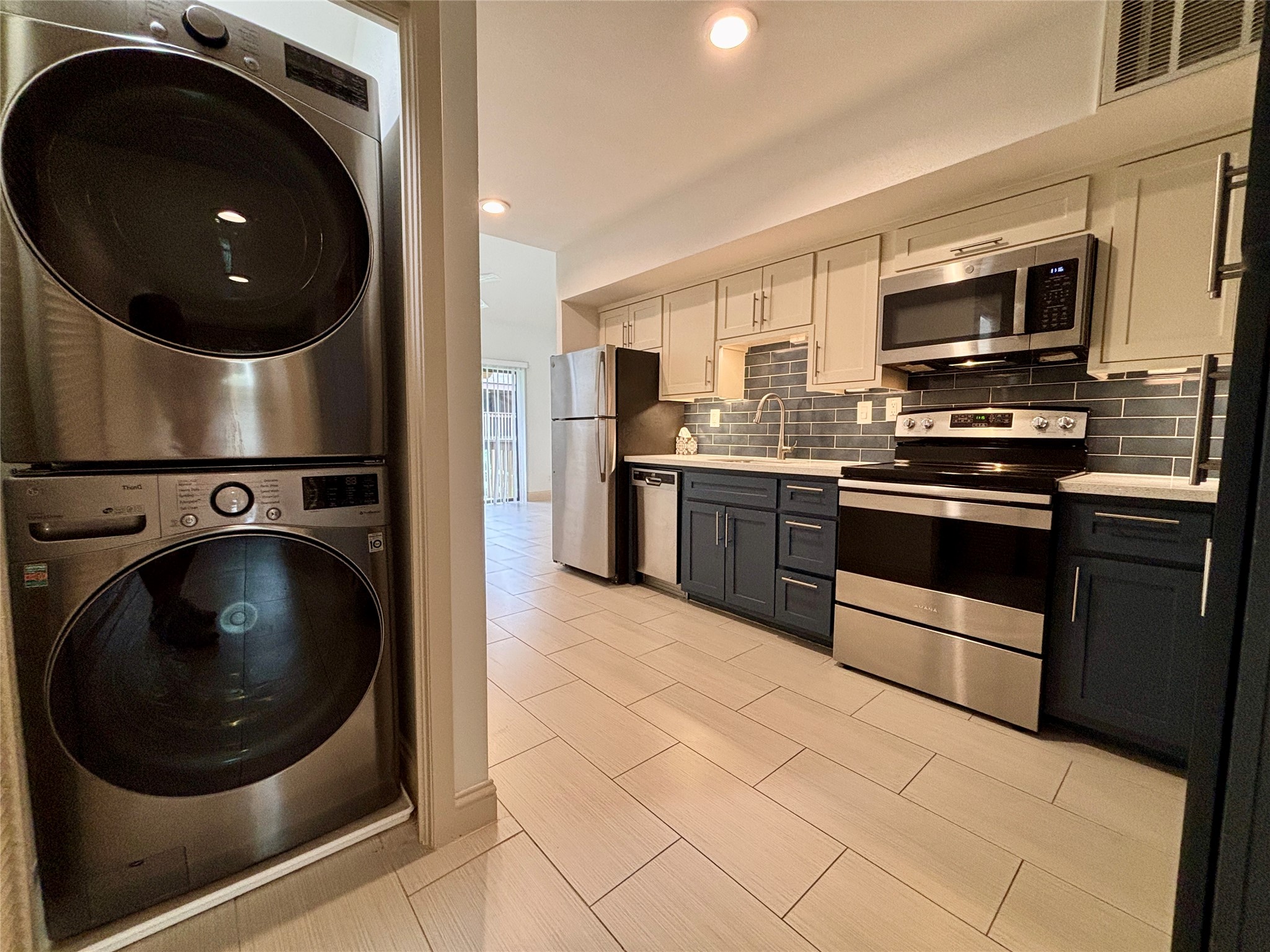 a kitchen with stainless steel appliances granite countertop a stove a microwave and a sink