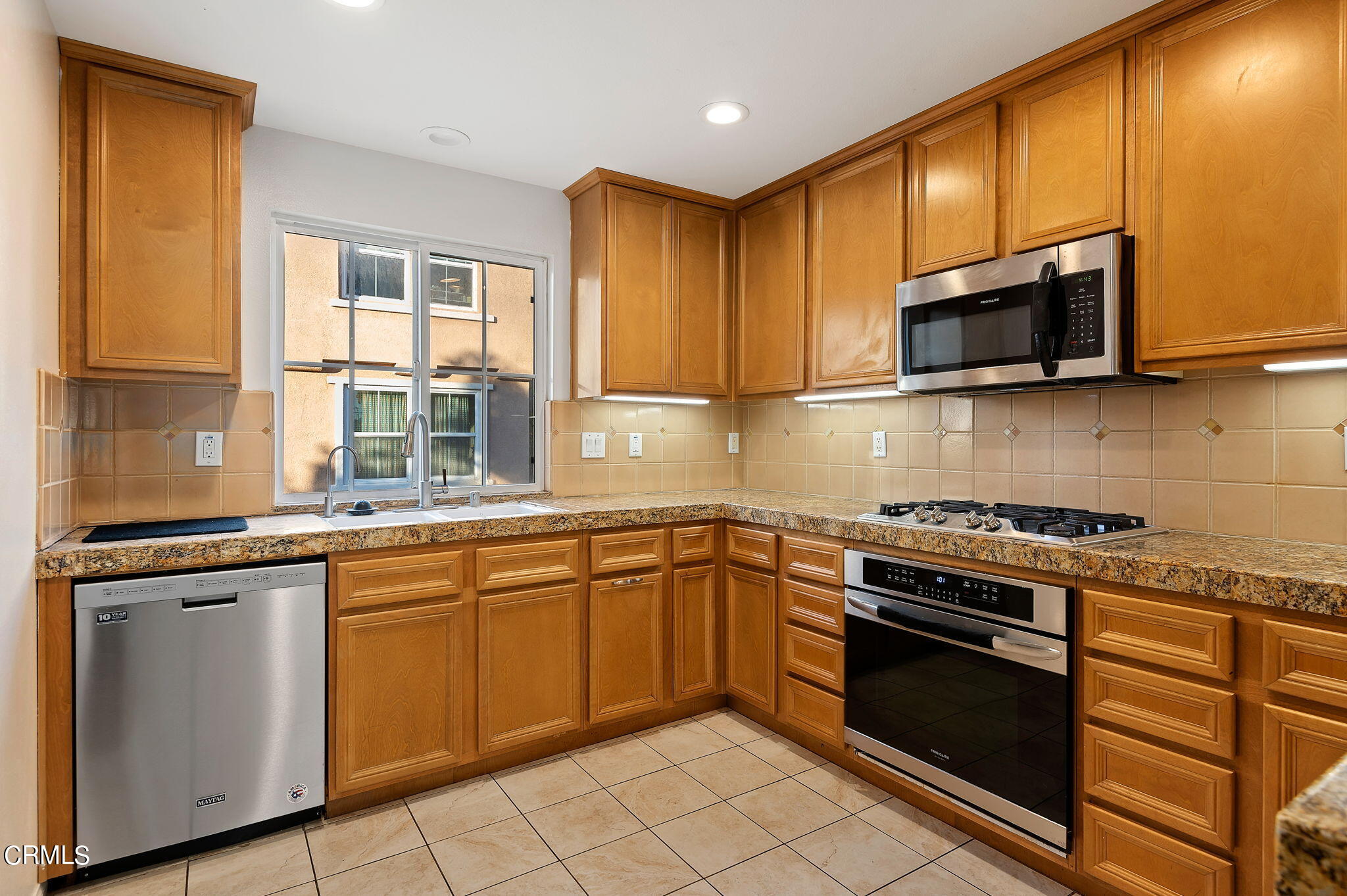 2824 Yacht Way Oxnard, CA 93035 - Photo 7 of 24 a kitchen with granite countertop wooden cabinets stainless steel appliances and a sink