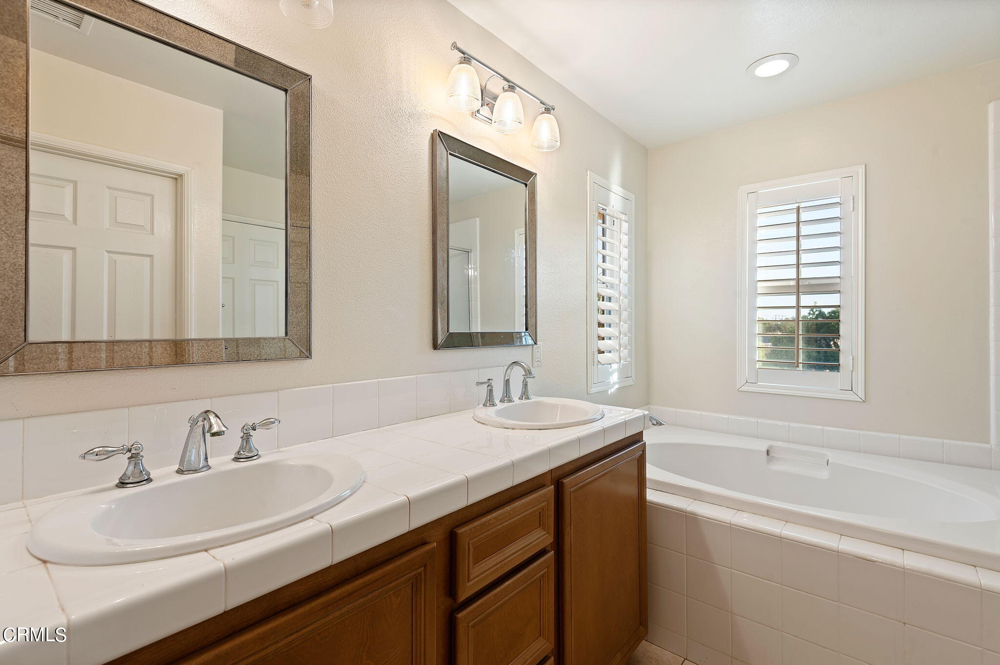 2824 Yacht Way Oxnard, CA 93035 - Photo 10 of 24 a bathroom with double vanity sinks a tub and a mirror