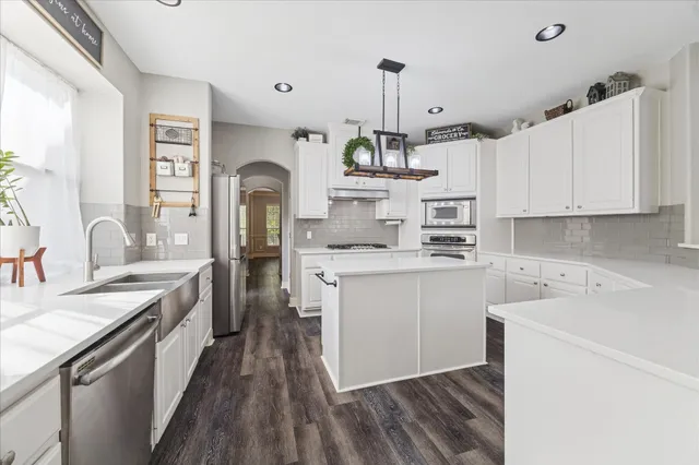 a kitchen with a sink stove and cabinets