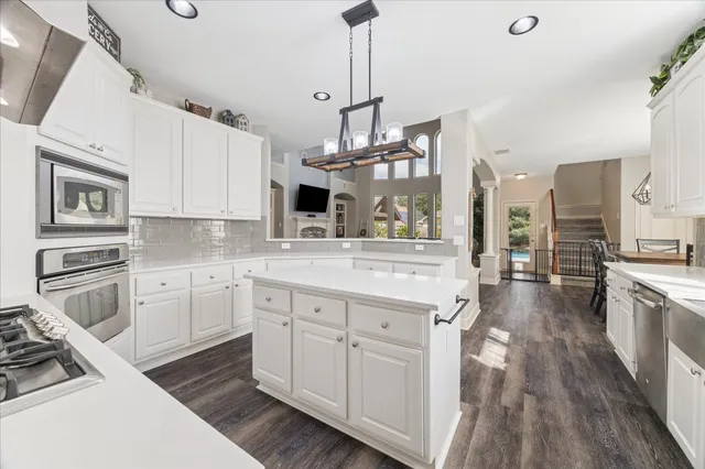 a kitchen with stainless steel appliances granite countertop a stove and white cabinets