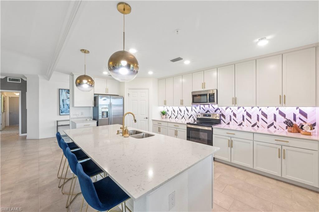 2373 Anguilla Drive, Unit 101 Naples, FL 34120 - Photo 1 of 32 a large kitchen with a table and chairs