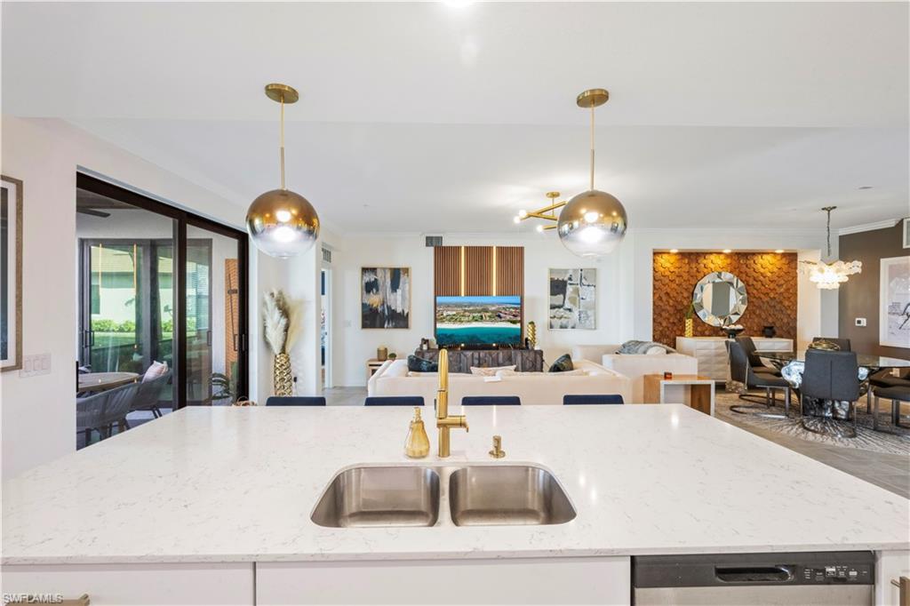 2373 Anguilla Drive, Unit 101 Naples, FL 34120 - Photo 11 of 32 a large living room with couches a chandelier and fireplace