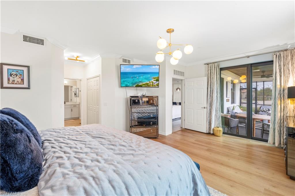 2373 Anguilla Drive, Unit 101 Naples, FL 34120 - Photo 13 of 32 a bedroom with a bed and a flat screen tv