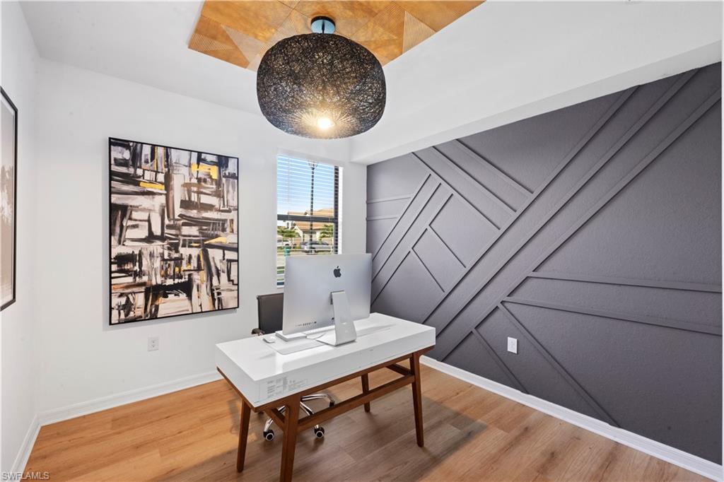 2373 Anguilla Drive, Unit 101 Naples, FL 34120 - Photo 17 of 32 a workspace with furniture and wooden floor