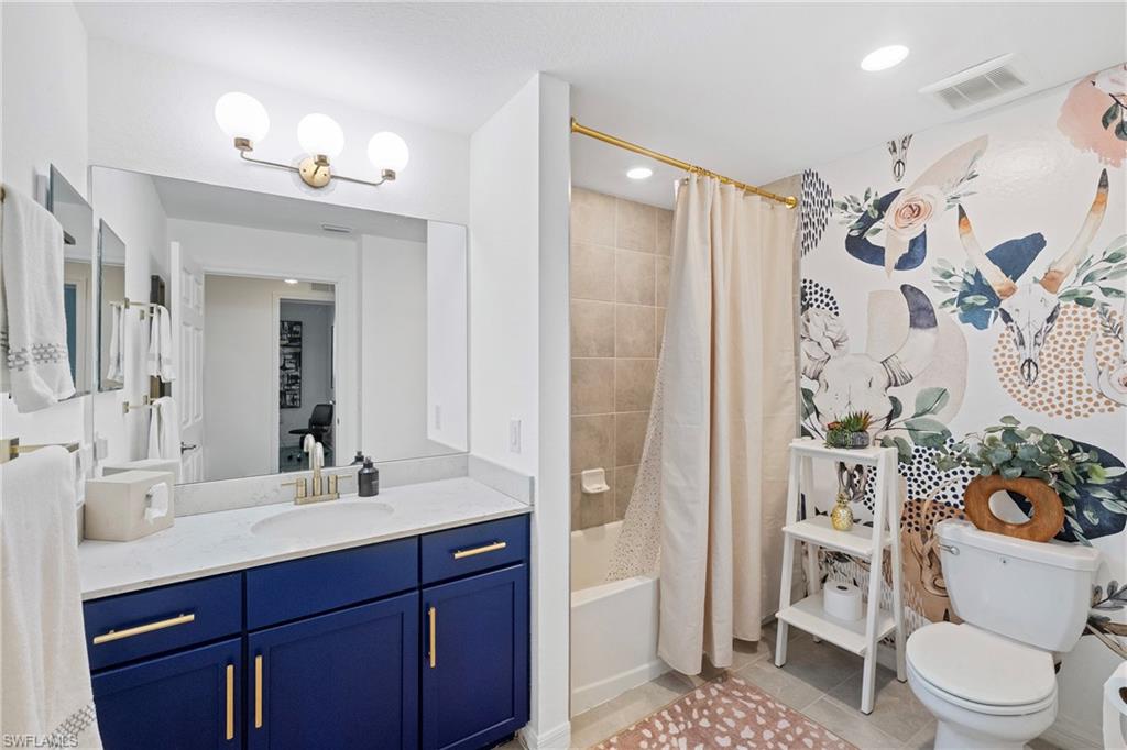 2373 Anguilla Drive, Unit 101 Naples, FL 34120 - Photo 20 of 32 a bathroom with a sink vanity mirror and toilet