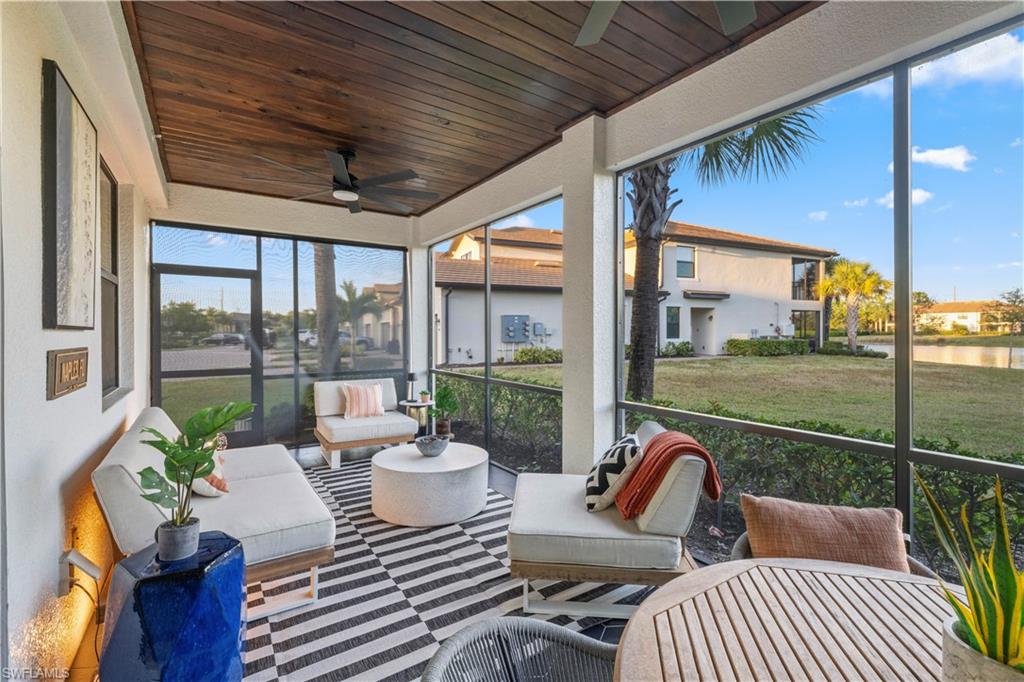 2373 Anguilla Drive, Unit 101 Naples, FL 34120 - Photo 21 of 32 a view of a patio with table and chairs potted plants with wooden floor and floor to ceiling window