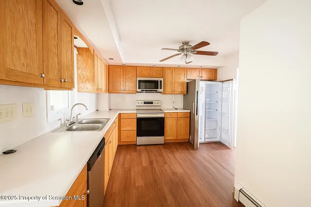 a kitchen with stainless steel appliances a stove a sink a refrigerator and cabinets