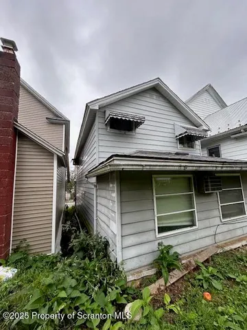 a view of a house with a yard and sitting area