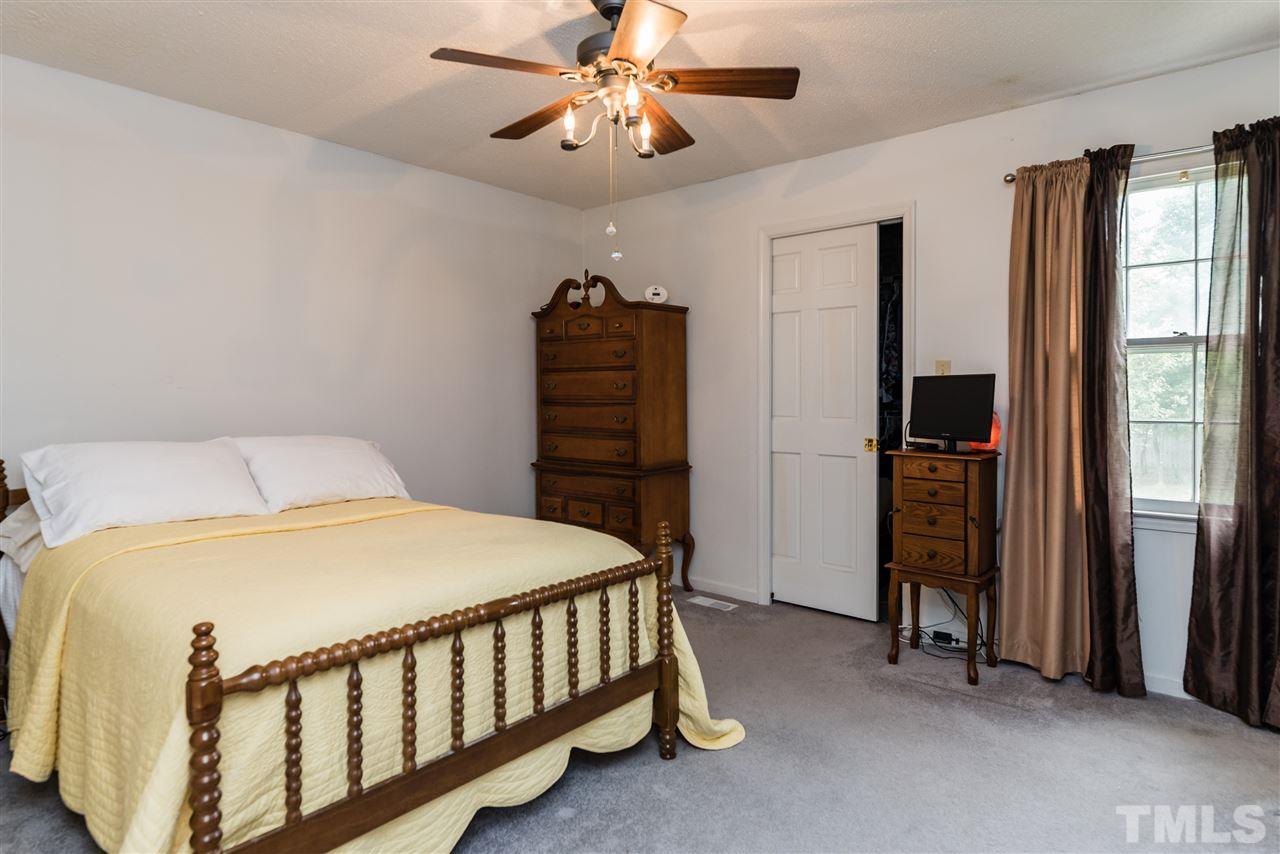 3929 Haithcock Road Raleigh, NC 27604 - Photo 5 of 11 a bedroom with a bed and a chandelier