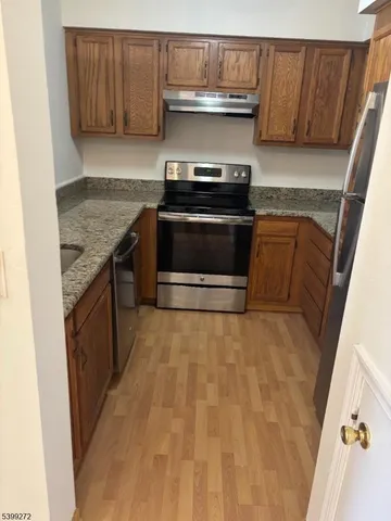 a kitchen with granite countertop a stove and a sink
