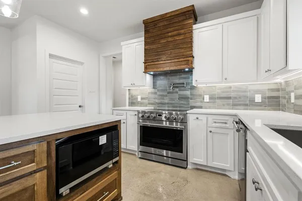 a kitchen with kitchen island a sink stainless steel appliances and cabinets