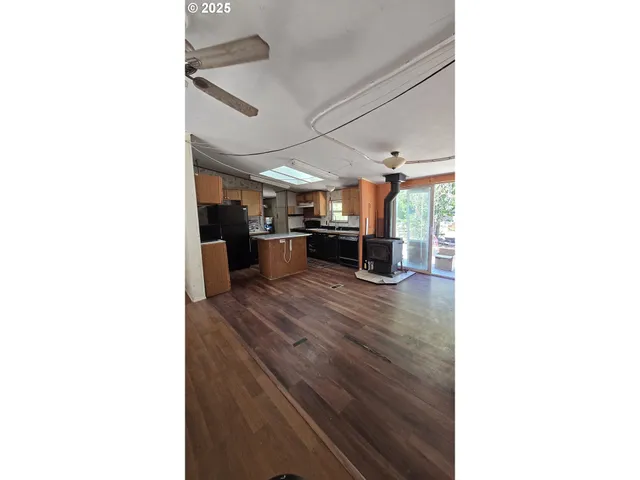 a kitchen with stainless steel appliances granite countertop a refrigerator a sink dishwasher a stove and a refrigerator