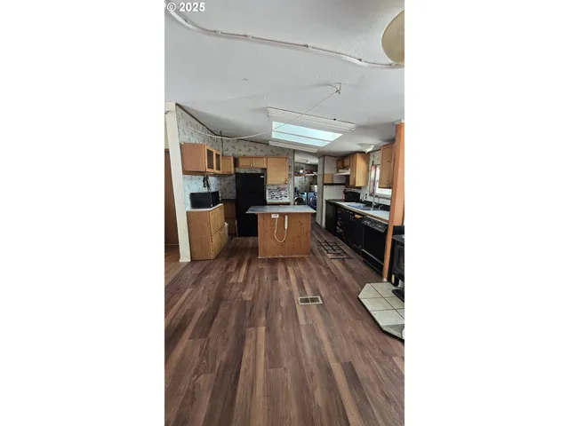 a kitchen with stainless steel appliances granite countertop a sink refrigerator and microwave