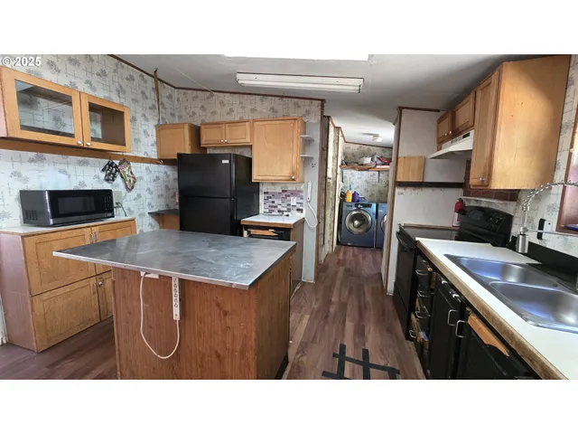 a black and white kitchen with a sink a refrigerator and a stove