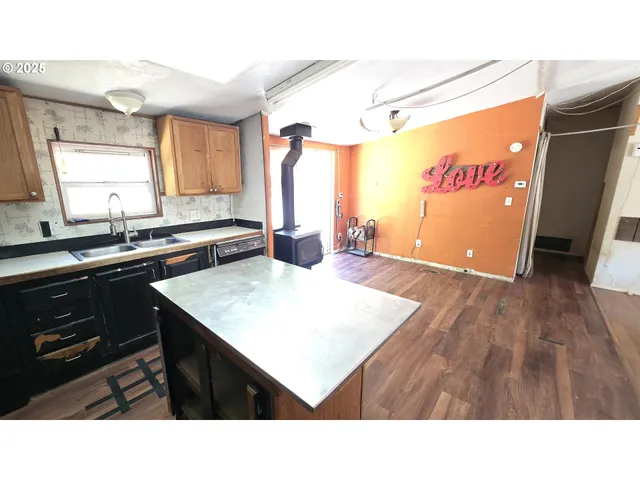 a kitchen with stainless steel appliances kitchen island granite countertop a stove a sink dishwasher and a microwave