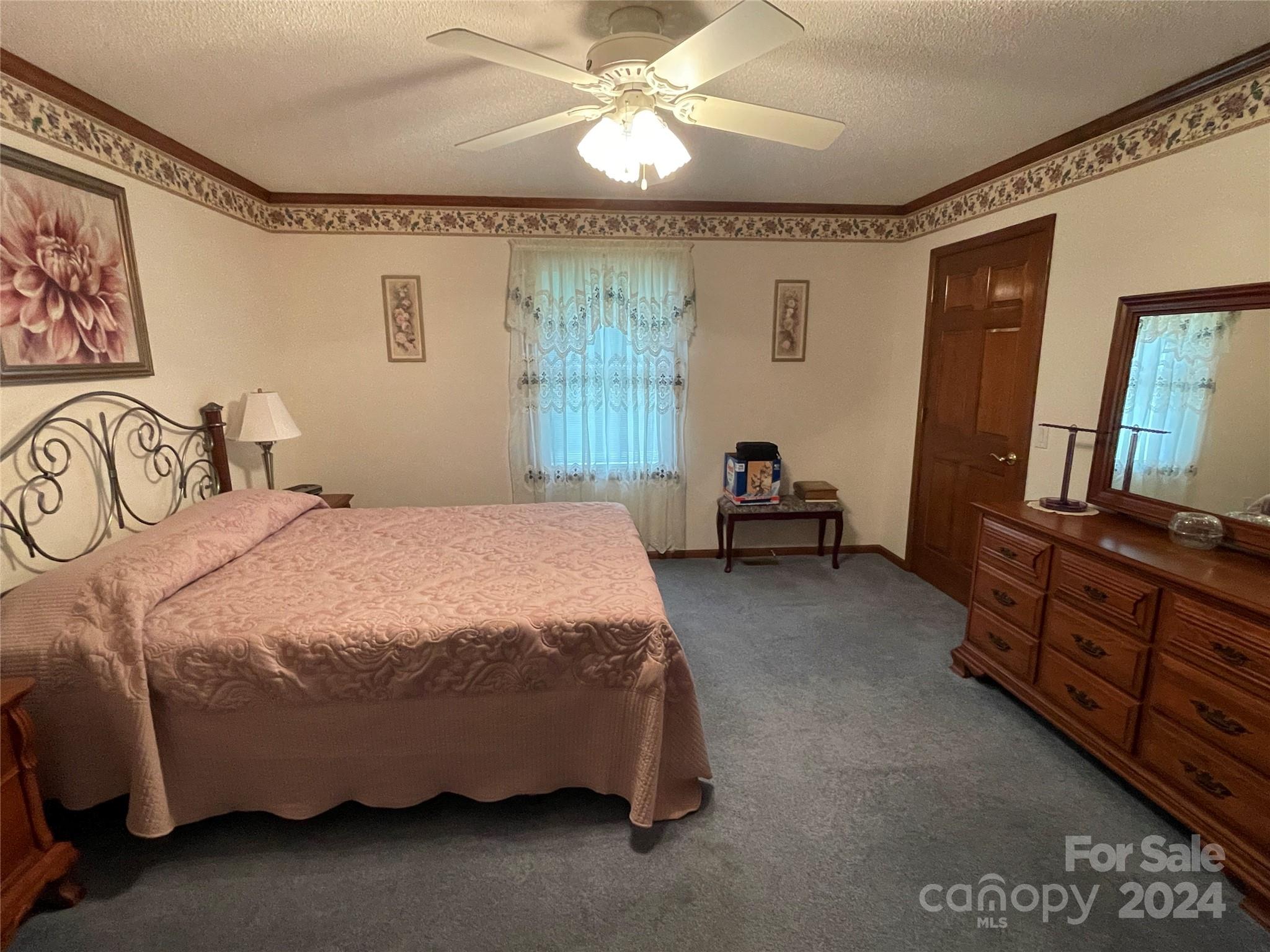 36345 Old Salisbury Road New London, NC 28127 - Photo 18 of 48 a spacious bedroom with a bed and a chandelier