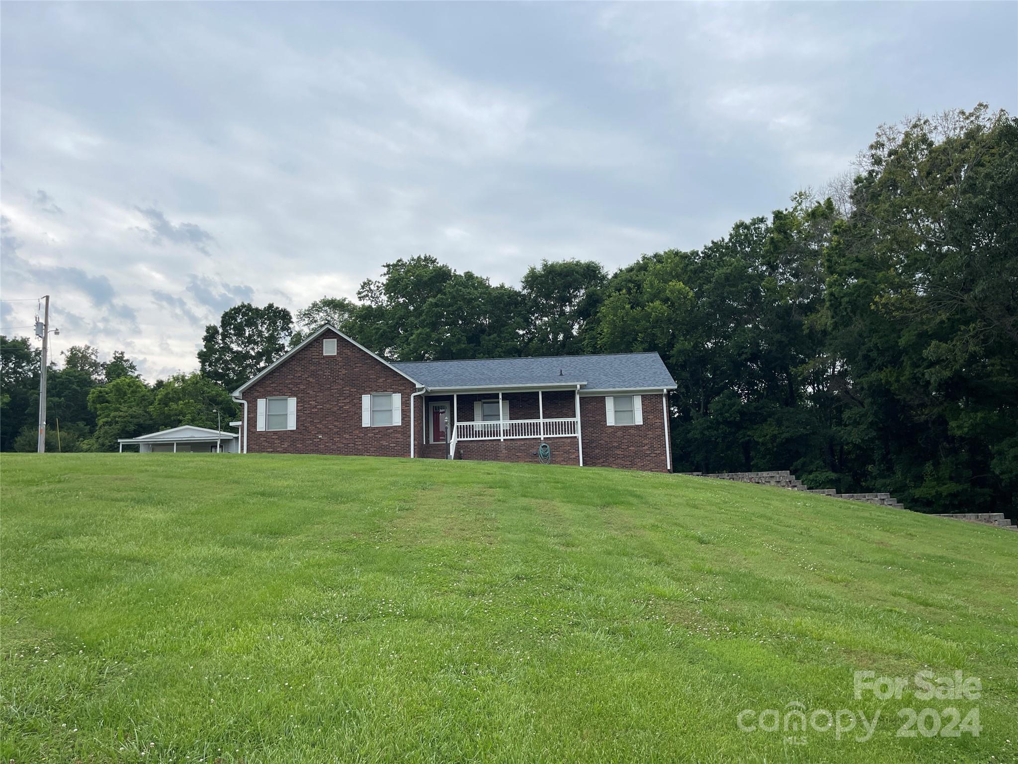 36345 Old Salisbury Road New London, NC 28127 - Photo 2 of 48 a view of a yard in front of a house with large trees