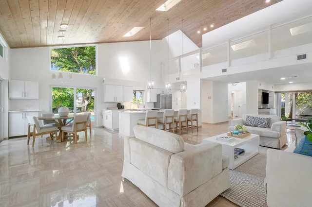 a view of a dining room with furniture a kitchen and chandelier