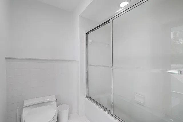a bathroom with a shower a toilet and sink