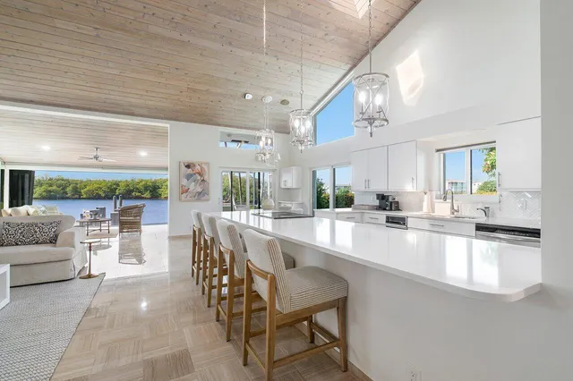 a large white kitchen with lots of counter space dining table and chairs