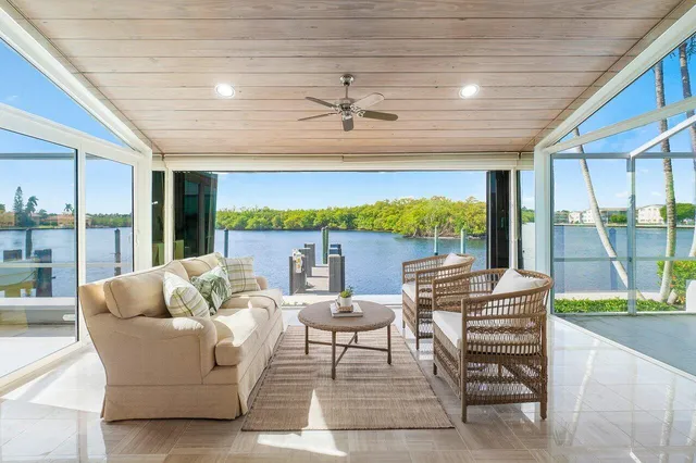 a living room with patio furniture and a floor to ceiling window