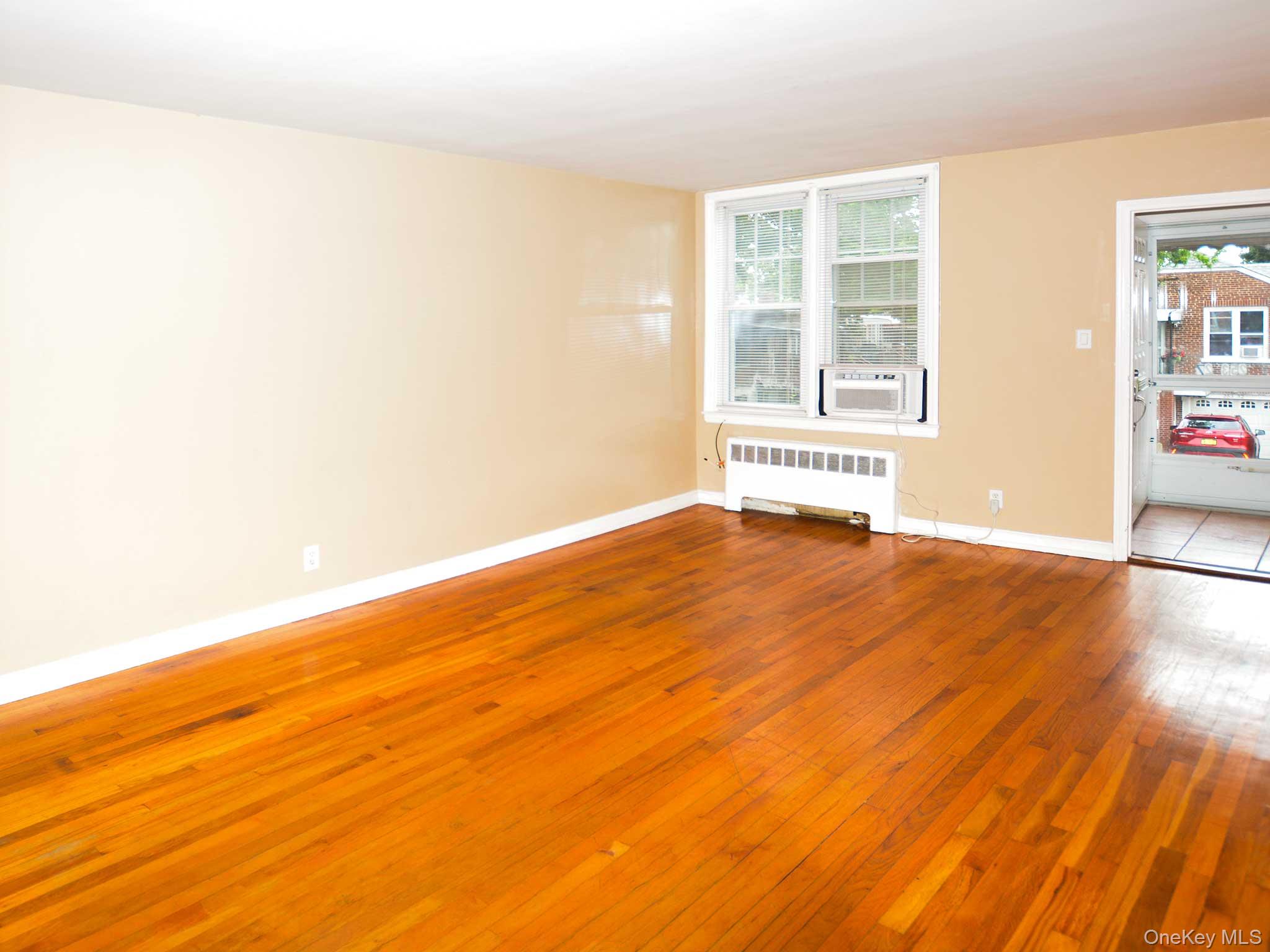 253-27 85th Road, Unit 2 Queens, NY 11426 - Photo 6 of 8 a view of an empty room with wooden floor and a window