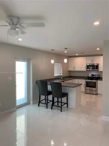 a kitchen with a sink and chairs