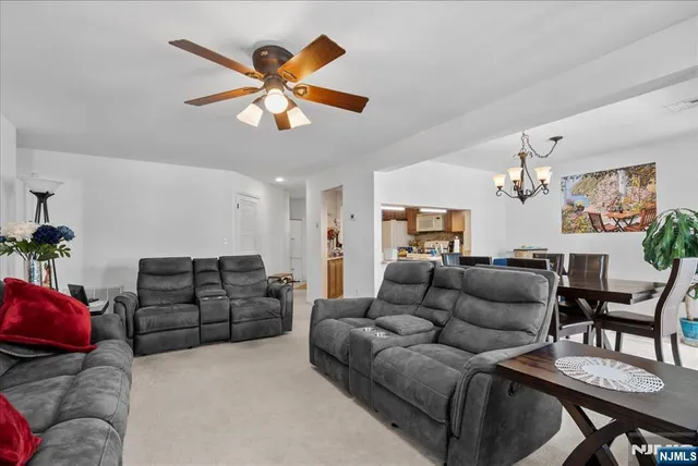 a living room with furniture a ceiling fan and a window