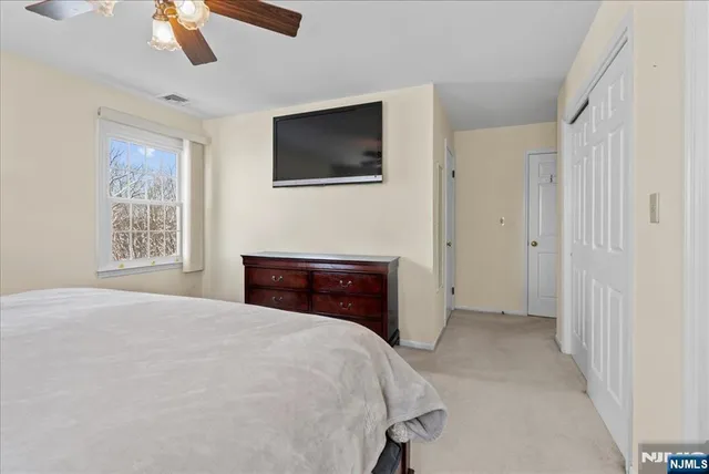 a spacious bedroom with a bed and a flat screen tv