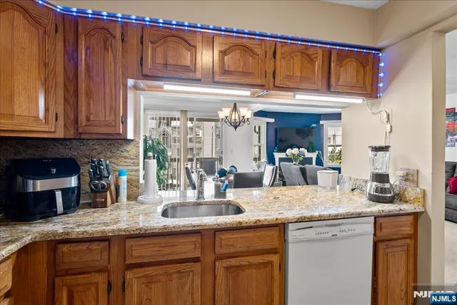 a kitchen with granite countertop a sink and a wooden cabinets