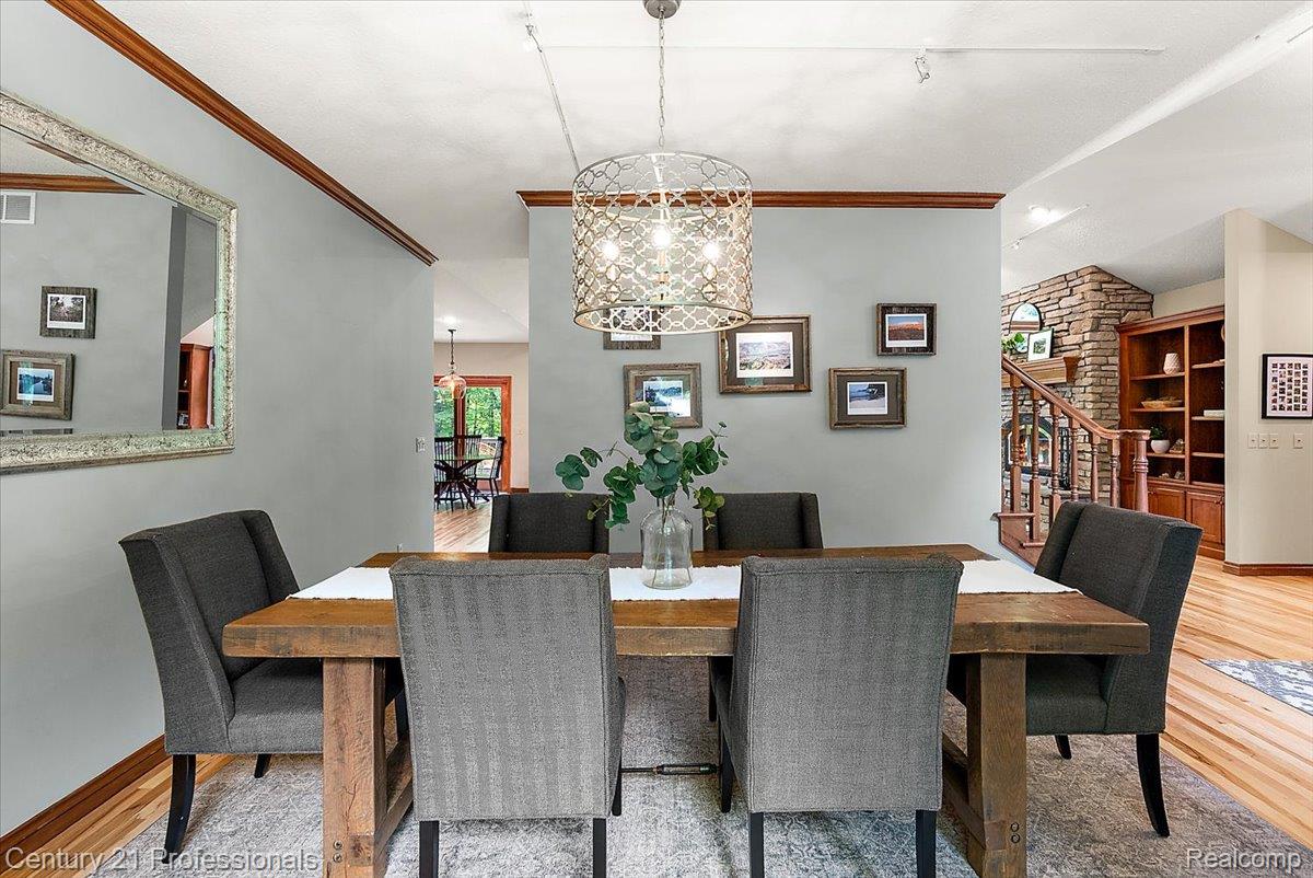 9867 Rainbow Ridge Drive Schoolcraft, MI 49087 - Photo 29 of 82 Dining area featuring a decorative chandelier, hardwood flooring, and a built-in shelving unit