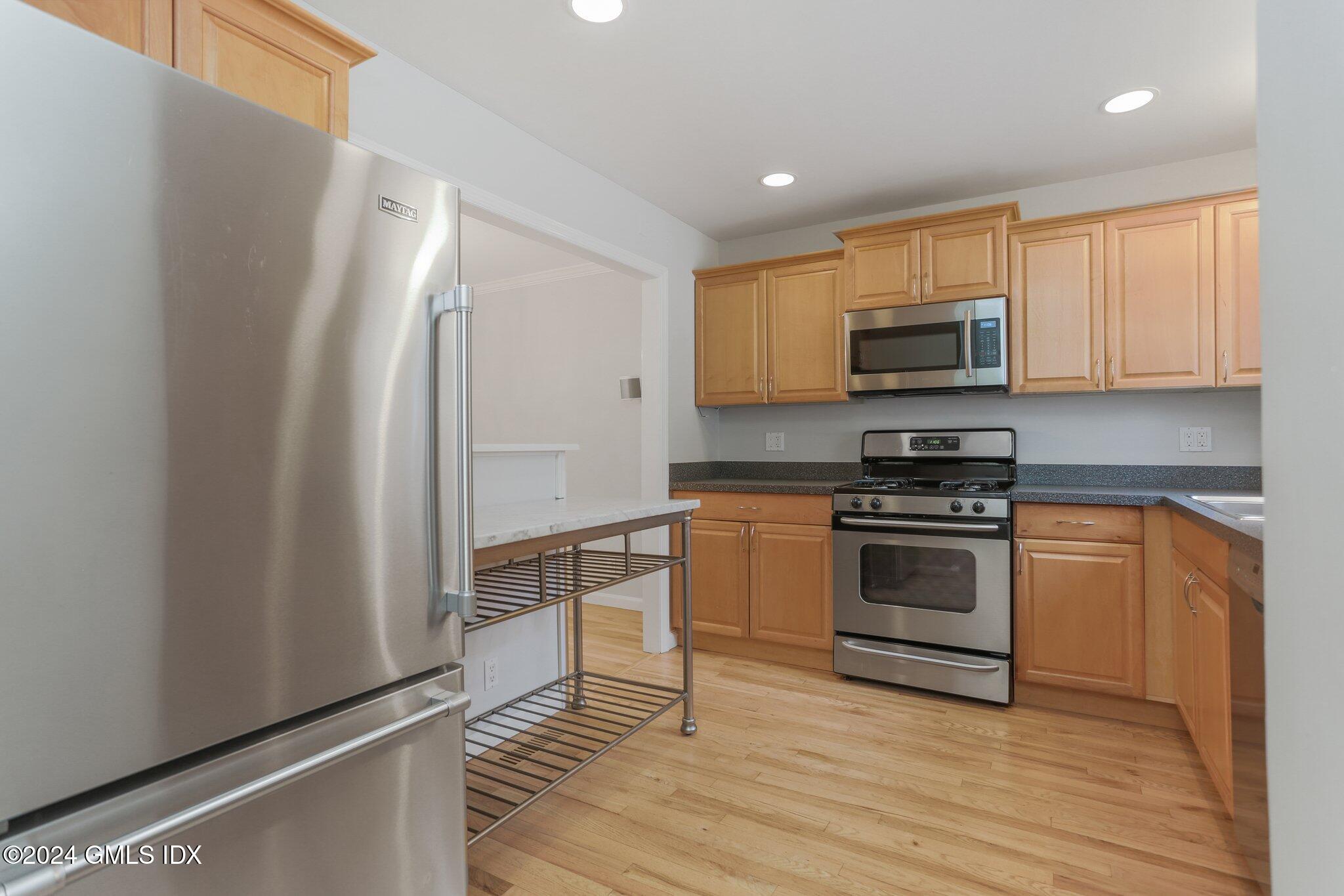 53 Bible Street, Unit 4 Cos Cob, CT 06807 - Photo 4 of 28 a kitchen with granite countertop a refrigerator stove and microwave