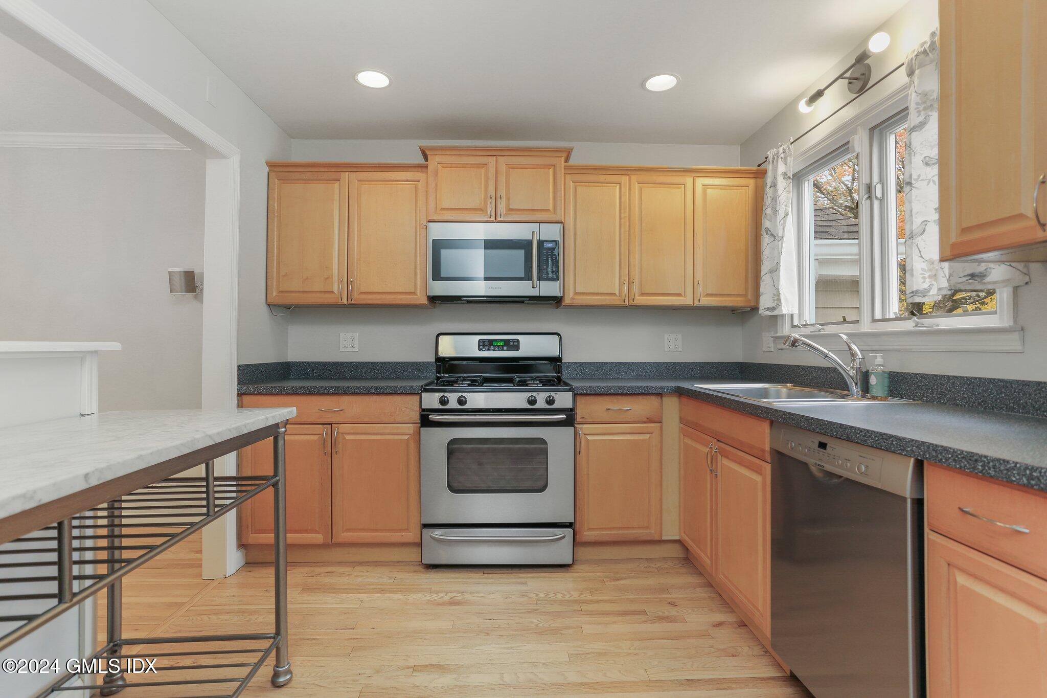 53 Bible Street, Unit 4 Cos Cob, CT 06807 - Photo 6 of 28 a kitchen with stainless steel appliances granite countertop a stove a sink and a microwave