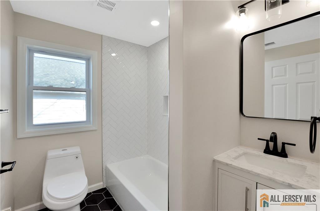 24 John Street Helmetta, NJ 08828 - Photo 11 of 18 a bathroom with a sink a toilet and a mirror