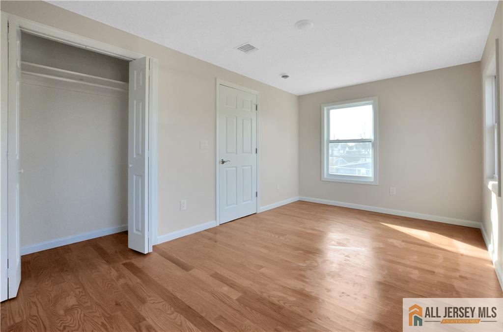 24 John Street Helmetta, NJ 08828 - Photo 15 of 18 a view of an empty room with wooden floor and a window