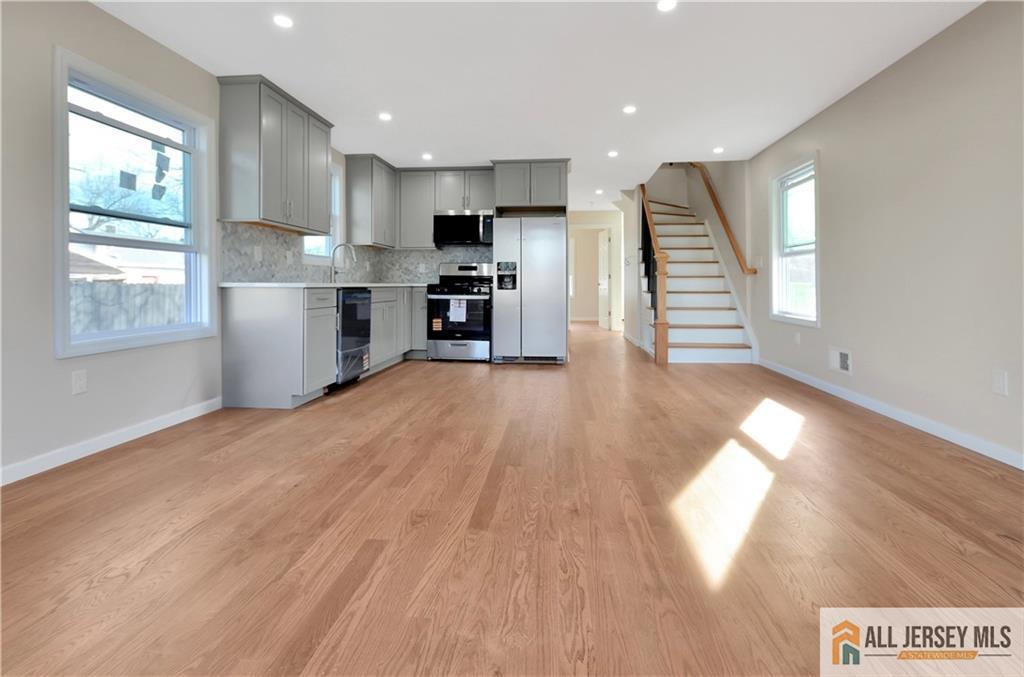 24 John Street Helmetta, NJ 08828 - Photo 5 of 18 a kitchen with stainless steel appliances granite countertop a refrigerator a sink dishwasher and a stove with wooden floor