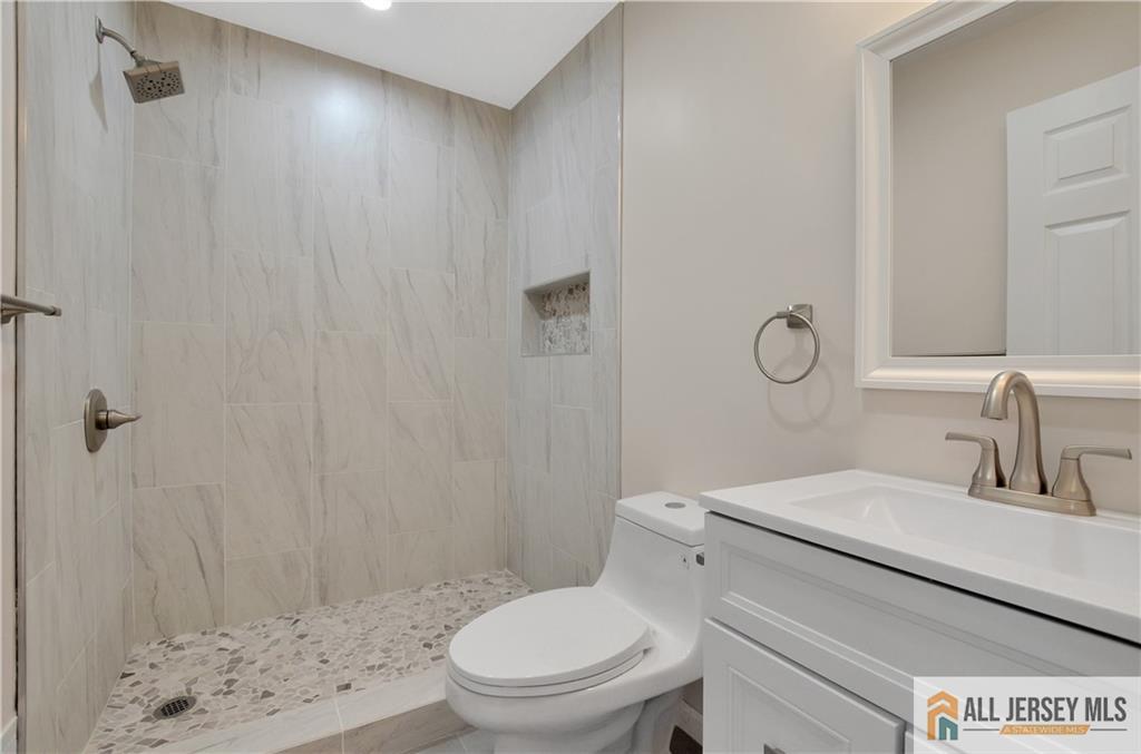 24 John Street Helmetta, NJ 08828 - Photo 9 of 18 a bathroom with a toilet a sink a shower and mirror