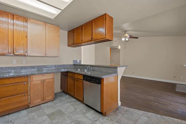 a kitchen with granite countertop cabinets stainless steel appliances and a sink