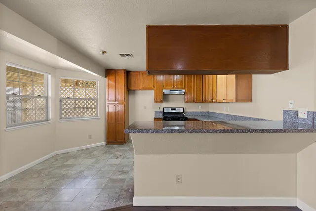 a kitchen with stainless steel appliances granite countertop a sink a stove and a refrigerator