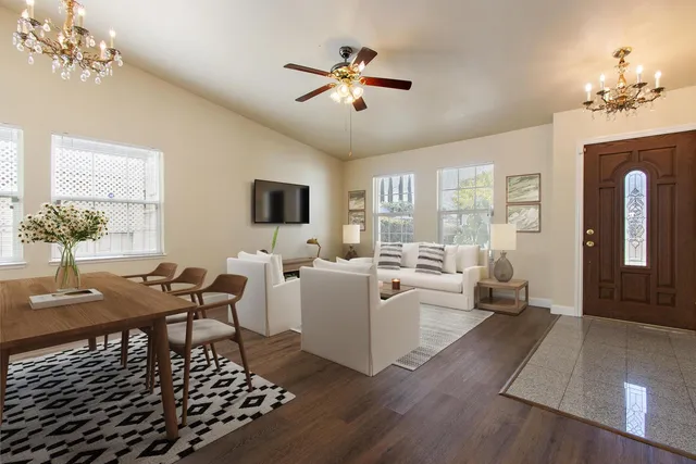 a living room with furniture a chandelier and a table