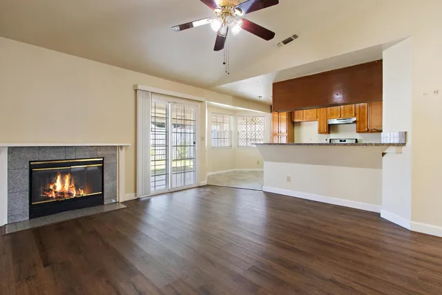 a view of an empty room with a fireplace and a window
