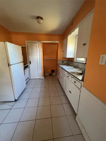 a kitchen with granite countertop a stove a sink and a refrigerator