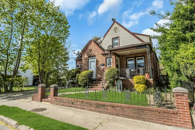 a front view of a house with a garden and plants