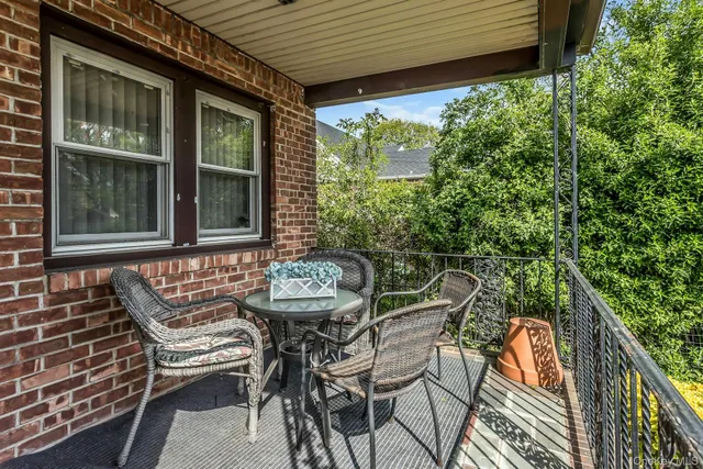a view of a patio with table and chairs with wooden floor and fence