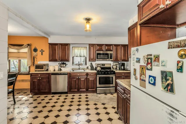 a kitchen with stainless steel appliances granite countertop a stove top oven a sink a dining table and chairs