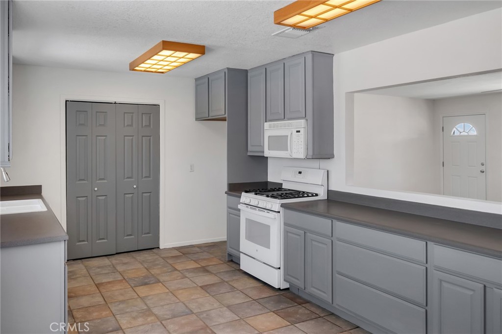 12736 Oasis Road Pinon Hills, CA 92372 - Photo 6 of 33 a kitchen with a stove cabinets and a window
