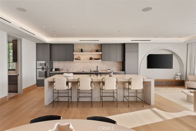 a large kitchen with stainless steel appliances granite countertop a lot of counter space and wooden floors