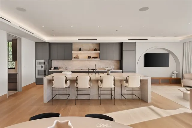 a large kitchen with stainless steel appliances granite countertop a lot of counter space and wooden floors